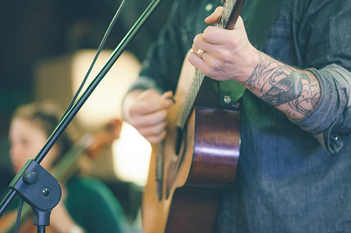 man playing an acoustic guitar on stage